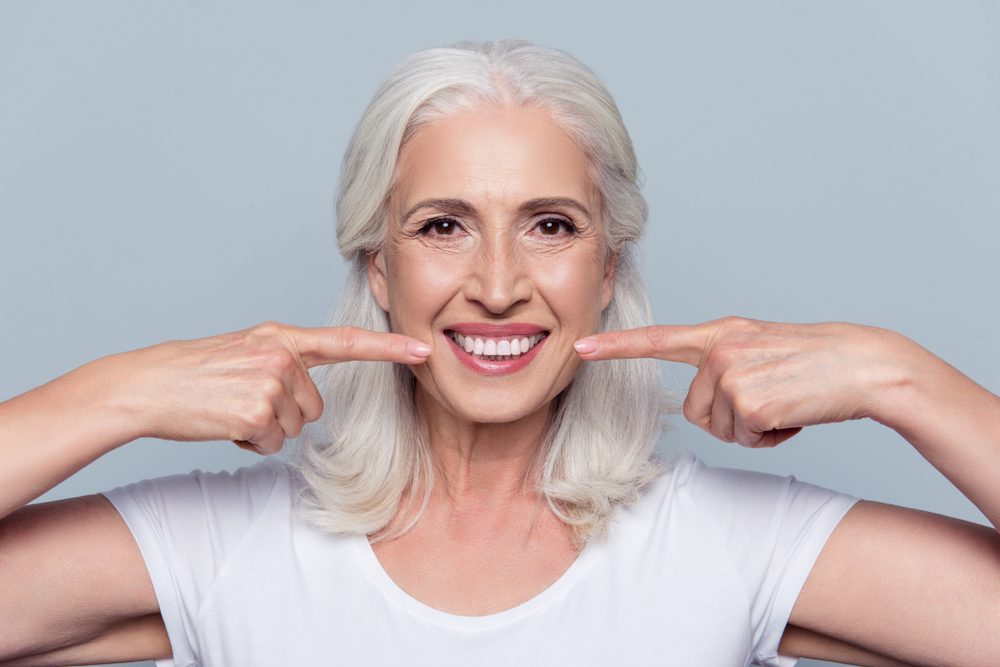 Very nice lady smiling pointing at mouth